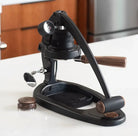 Black manual coffee grinder on a kitchen counter
