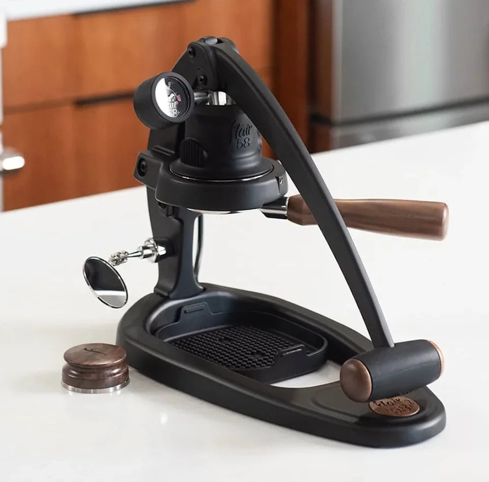 Black manual coffee grinder on a kitchen counter