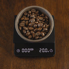 Flair Espresso Scale on a wooden countertop with beans and a weight of 20 grams.