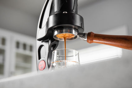 Espresso being poured from a coffee machine into a glass.