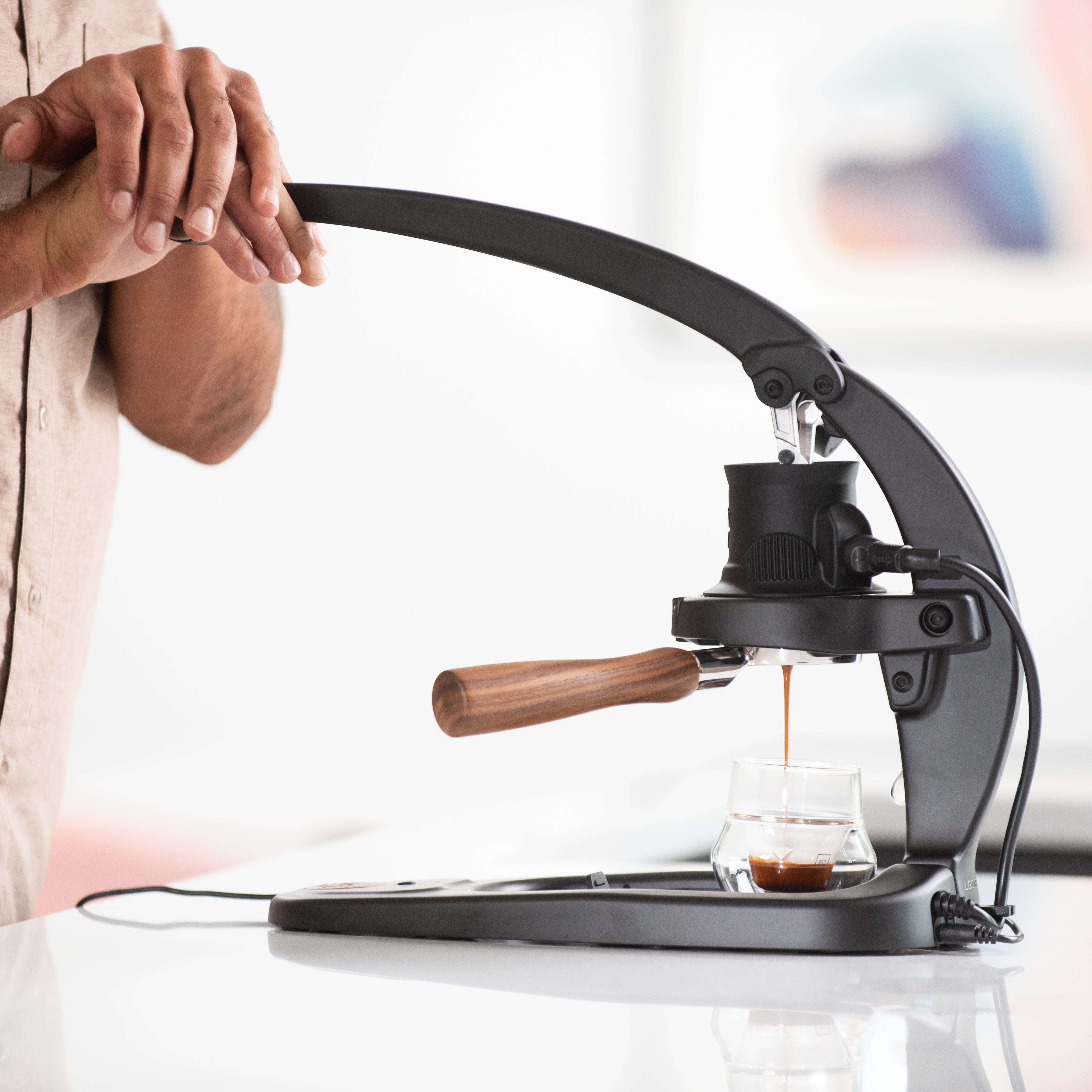 Manual coffee press being used with a blurred background