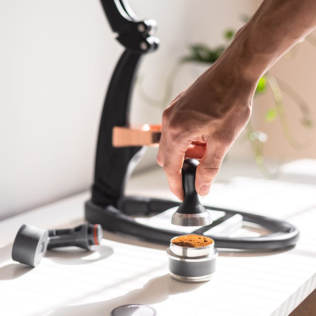 A Barista Using The Flair Espresso Maker Is A Non-electric Coffee Brewing  Device Using A Lever Or Handle. For Extracting Espresso On A Table With  Coffee Making Iced Coffee. Soft Focus Stock